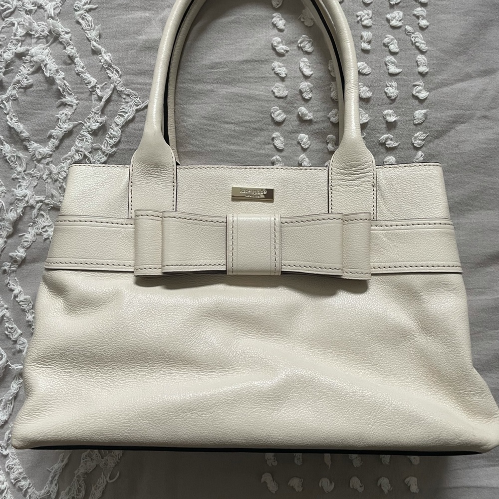 Cream Kate Spade bag with black/white polka dot interior lining
